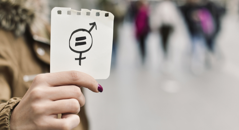 A woman holding up a symbol for gender equality