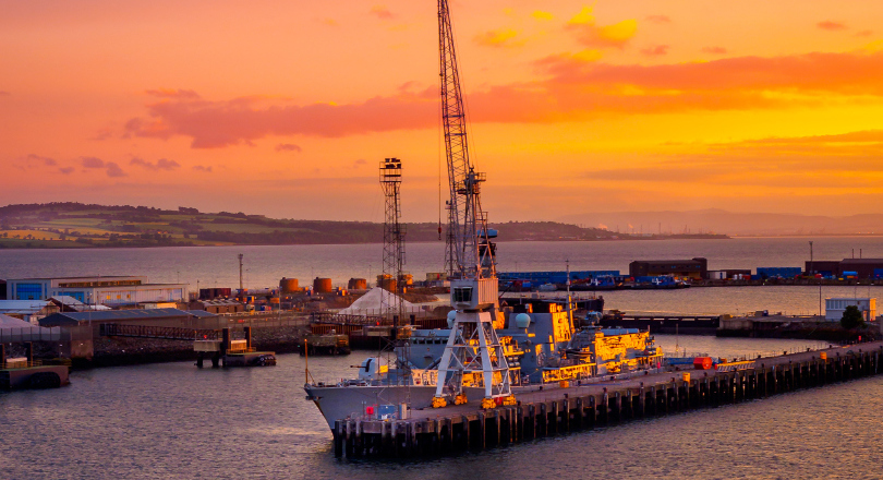 Rosyth at sunset with naval vessel moored